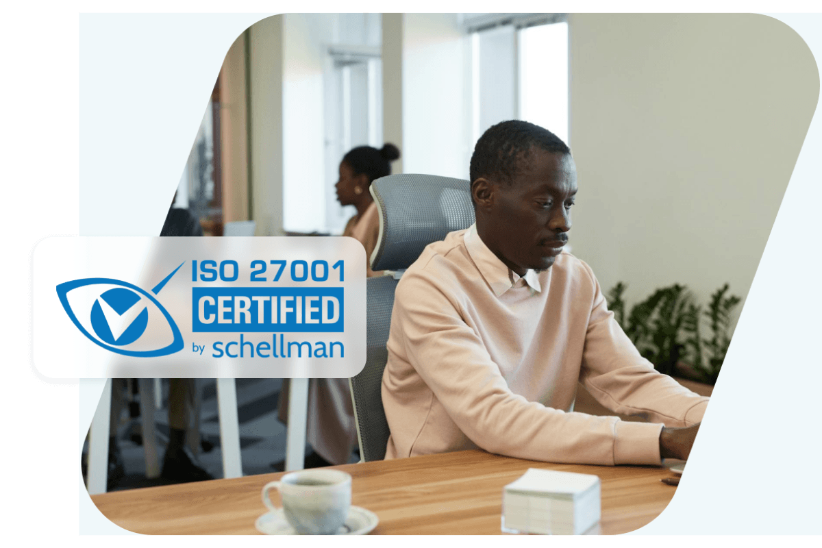 Image showing a man working at his desk overlaid with a badge representing Dashlane’s ISO-27001 certification.
