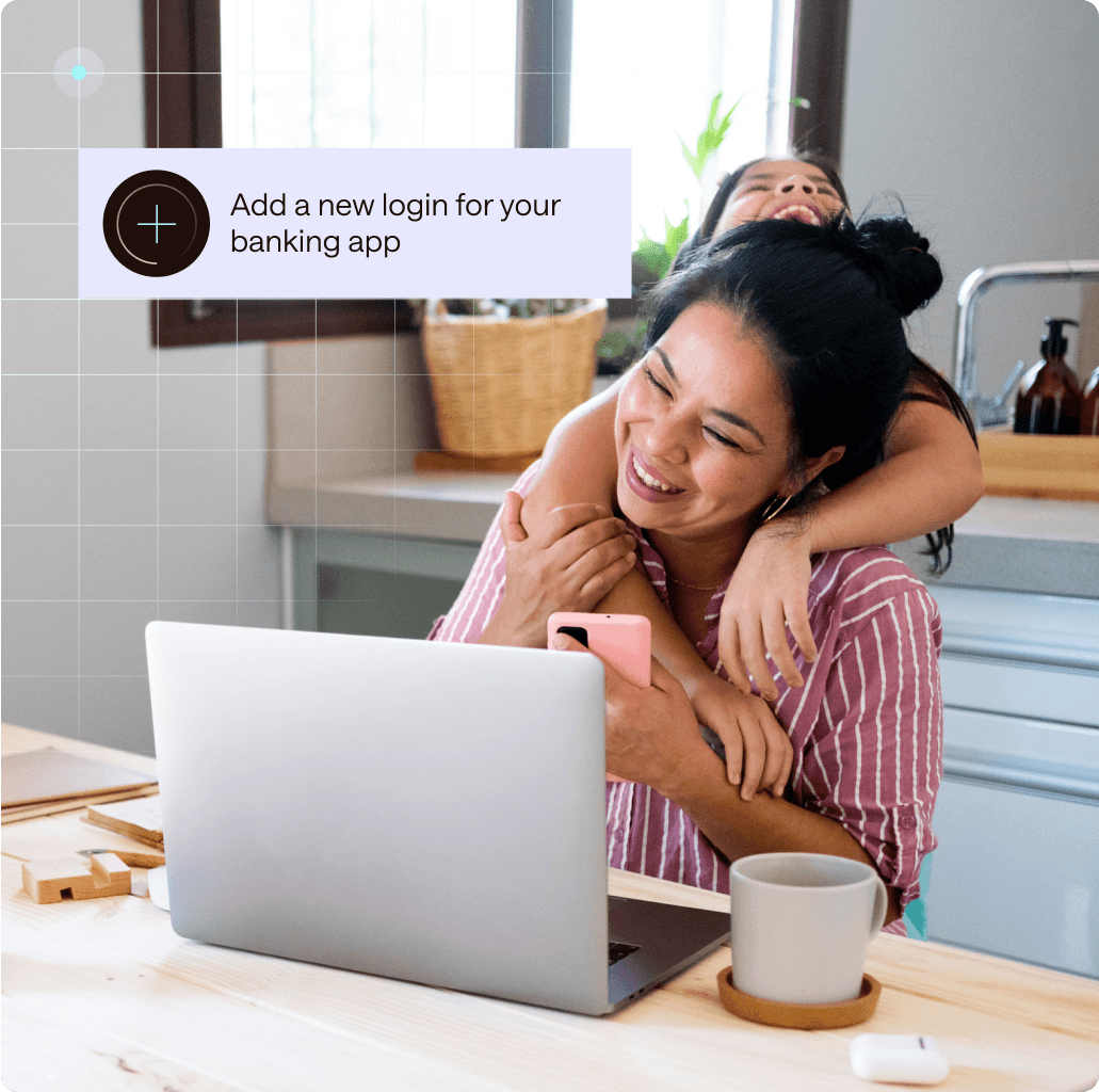 An image of a woman with dark hair in a dark pink and white-striped shirt holding a cell phone and sitting in front of a laptop as her dark-haired child hugs her from behind. An illustration of a Dashlane product screen that says “Add a new login for your banking app” appears on her left.