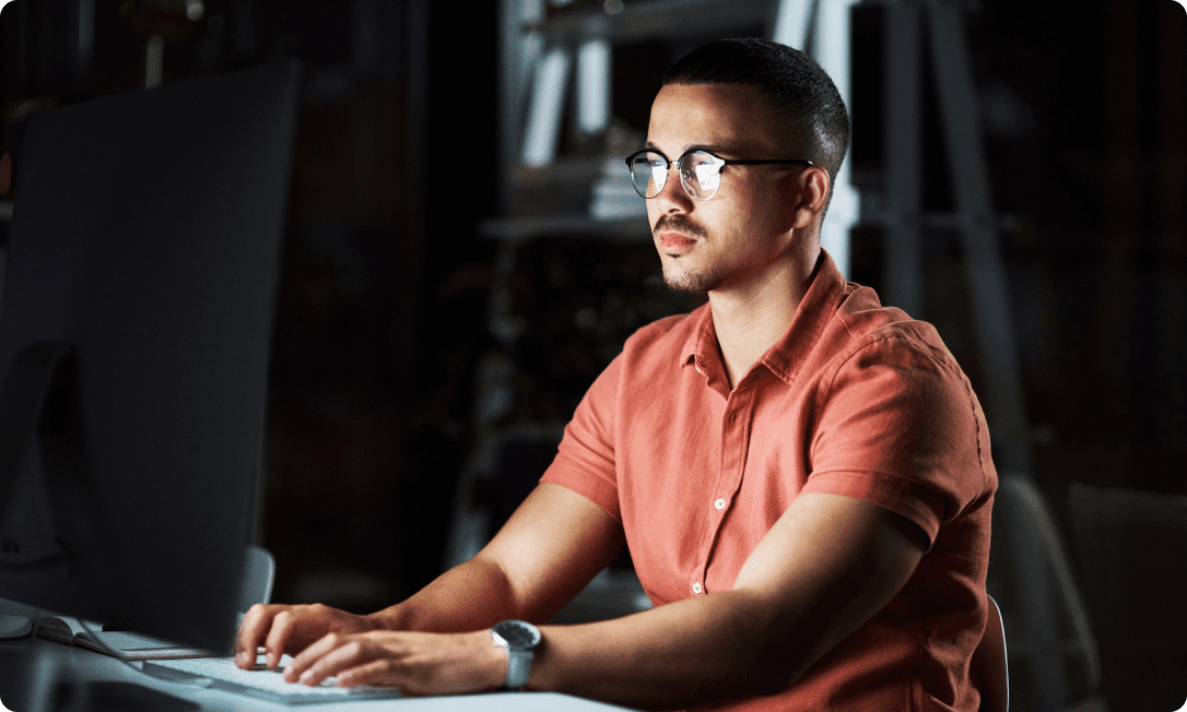 An employee at their desk receiving a Dashlane credential risk alert in the browser, prompted to immediately fix a weak or compromised password.