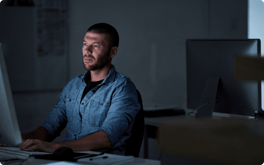 Man works at his computer receives AI phishing alert.