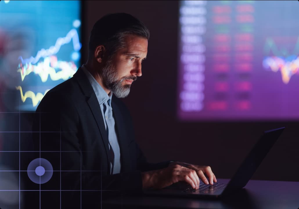 Man look at computer with graphs in the background