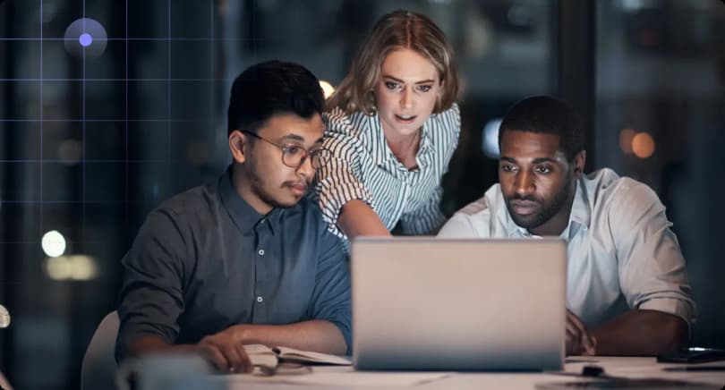 three people looking at computer